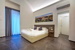 拉古萨Ad Maiora - Design Rooms的卧室配有一张床,墙上挂有绘画作品