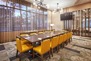 安纳海姆Cambria Hotel & Suites Anaheim Resort Area的一间会议室,配有长桌子和黄色椅子