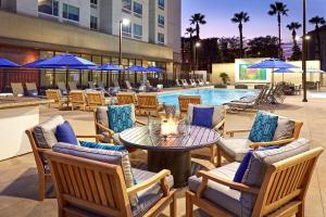 安纳海姆Cambria Hotel & Suites Anaheim Resort Area的一个带桌椅的庭院和一个游泳池