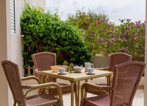 圣费兰-德瑟斯罗Es Garrovers - Formentera Break的露台上的桌椅,包括杯子和碗