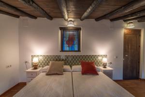 PadulAl Agia - Mirador Alto Cijancos的一间卧室配有一张带两盏灯的床和彩色玻璃窗。