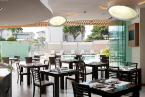 利多迪耶索罗伊尔德亚托酒店的一间带桌椅的餐厅和一个游泳池