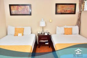 马那瓜洛斯西斯内罗斯公寓酒店的客房设有两张床和一张带台灯的桌子。