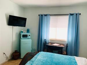 迈阿密海滩Blue House Miami的一间卧室配有一张床和一张带微波炉的桌子。