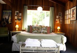 Little RiverThe Andiron Seaside Inn & Cabins的一间卧室设有一张大床和窗户