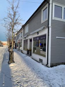 莫舍恩Mosjøen Overnatting, Cm havigs gate 18的一座被雪覆盖的街道,位于大楼旁边