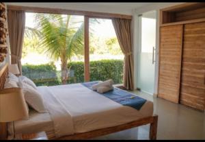 海神庙蒂萨瓦别墅酒店的一间卧室设有一张床和一个大窗户