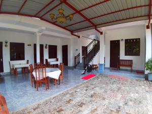 波隆纳鲁沃拉达旅客之家旅馆的客厅设有桌椅和天花板。