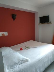 Ternand拉达姆德梅西涅克度假屋的卧室配有白色的床铺和红色的墙壁