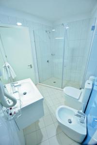 莱什Jolly Hotel的浴室配有卫生间、盥洗盆和淋浴。