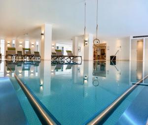 丰塔内拉Spa-Hotel Das Schäfer的一座带玻璃墙的游泳池