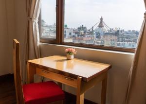 加德满都若帕旅馆的一张木桌,窗户前配有红色椅子