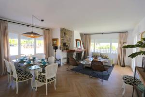 托雷德本纳贾尔邦VILLA LUNA Beach Premium 9PAX的用餐室以及带桌椅的起居室。