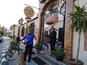达哈布TheCastle Hotel的两个人站在建筑物外,骑着自行车