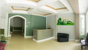 班塔延岛Sandscape Hotel的一间设有绿色墙壁和黑椅的客房