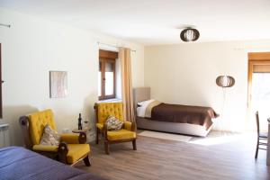 AndrijevicaZvjezdana dolina Garni hotel的一间卧室配有一张床、两把椅子和一张床
