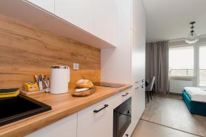 华沙Warsaw To Be - Silver Apartment的厨房配有白色橱柜和台面