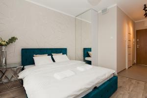 华沙Warsaw To Be - Silver Apartment的一间卧室配有一张大床和蓝色床头板