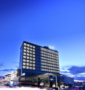 安卡拉Ankara Alegria Business Hotel的一座高大的建筑,上面有蓝色的灯光