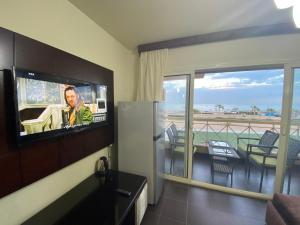 艾因苏赫纳Porto South Beach Royal Sea view families صف اول بحر مباشر的客房设有平面电视和阳台。