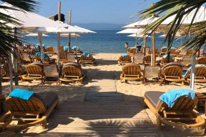 奥弗里安Kasta Beach Hotel的海滩上的一组椅子和遮阳伞