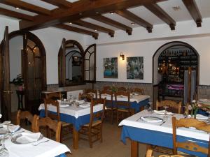 普拉多德尔雷卡伊科酒店的餐厅配有白色桌椅和蓝色桌布