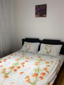 卡夫尼克19 RESIDENCE apartment的一张带花卉棉被和两个枕头的床