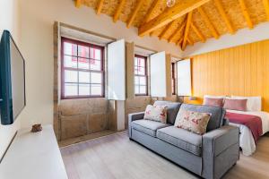 波尔图Lemago Porto Apartments - São Bento的客厅配有沙发和1张床
