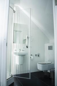 克洛佩夫尼茨基古苏达尔酒店的白色的浴室设有水槽和卫生间。