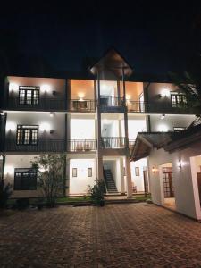 阿努拉德普勒Mindana Residence的夜间大型公寓楼,有砖车道