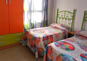 滨海罗克塔斯Precioso piso en Roquetas de Mar的一间带两张床和梳妆台的卧室