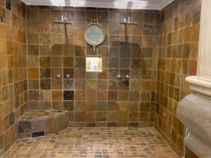 比勒陀利亚La-Perna Guesthouse and Venue的浴室配有瓷砖淋浴和浴缸