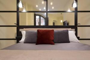 卡利亚里Suite Cagliari -99-的一间卧室配有一张带两个枕头和镜子的床