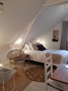 SteenwerckChambres D´Hôtes Herbes Folles的一间卧室配有一张床、一把椅子和一张桌子
