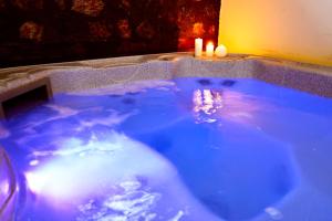 帕雷斯阿吉萨那ROUGA Mountain Boutique Suites & Spa的大型蓝色浴缸,内有两根蜡烛