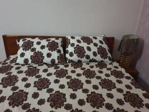 巴马科IMMEUBLE KCF的一张配有棕色和白色床单及枕头的床