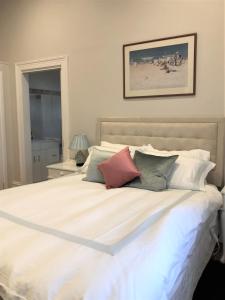 莫尔登费尔班克之家度假屋的卧室配有带枕头的大型白色床