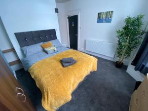 克鲁Bentley House with en-suites的一间卧室配有一张黄色毯子床