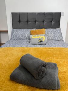 克鲁Bentley House with en-suites的一间卧室配有一张带床头板和毛巾的床