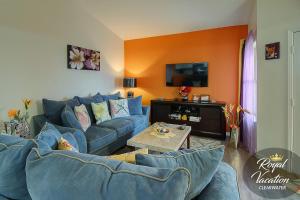 克利尔沃特Avalon Paradise的客厅设有蓝色的沙发和橙色的墙壁