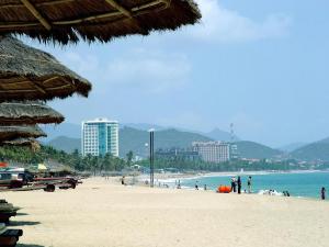芽庄Phu Quy Hotel的一片拥有人民和海洋的海滩和建筑