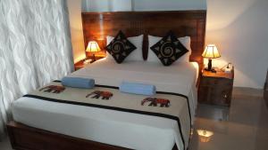 康提莎尼坎迪旅馆的一间卧室配有一张带两盏灯的大型白色床。