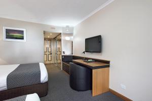 朗塞斯顿科摩多里根酒店的配有一张床和一台平面电视的酒店客房