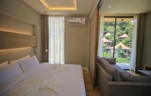 奥南海滩Rocco Aonang Krabi的一间卧室配有一张床、一张沙发和一个窗口
