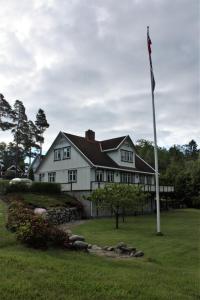 莫斯Huset i skogen的院子里有旗杆的白色房子