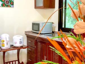 班农塔勒Kannapat House的厨房配有微波炉和带胡萝卜的柜台。