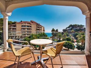 阿尔姆尼卡卡萨布兰卡酒店的阳台配有桌椅,享有海景。