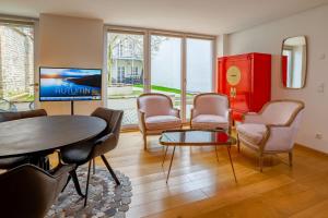 奥格斯堡ANA Living Augsburg City Center by Arthotel ANA - Self-Service-Hotel的客厅配有桌椅和红色橱柜