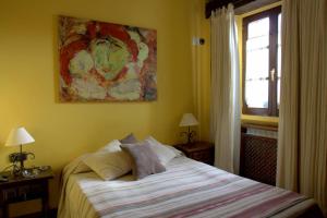 莱昆韦里埃洛斯塔乡村旅馆的卧室配有一张床,墙上挂有绘画作品