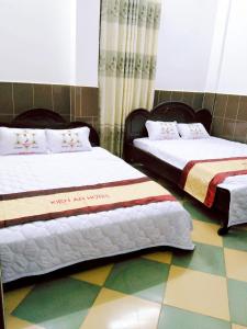 芹苴Kiến An Hotel Cần Thơ的两张睡床彼此相邻,位于一个房间里